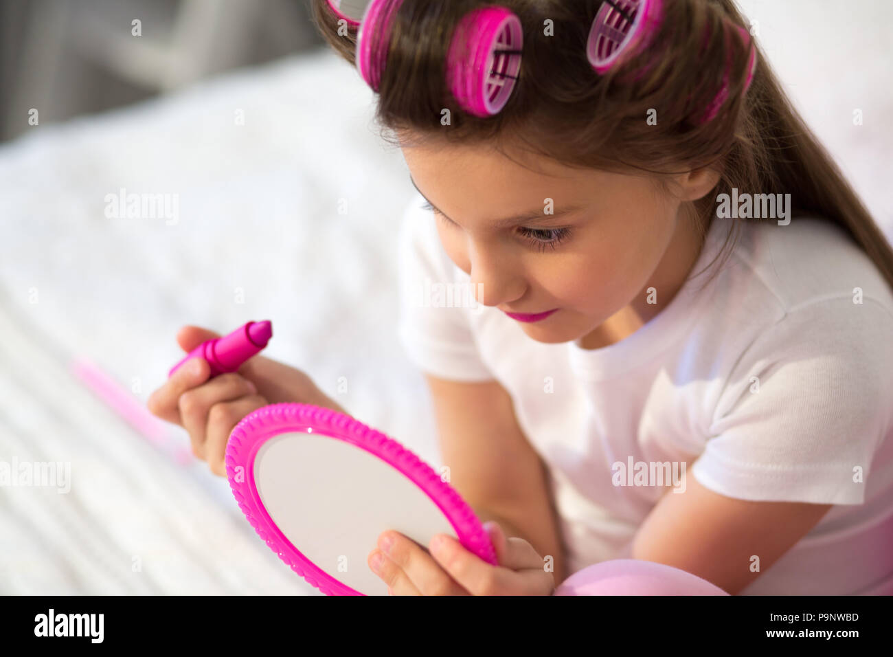 Cute girl putting on make up. Stock Photo