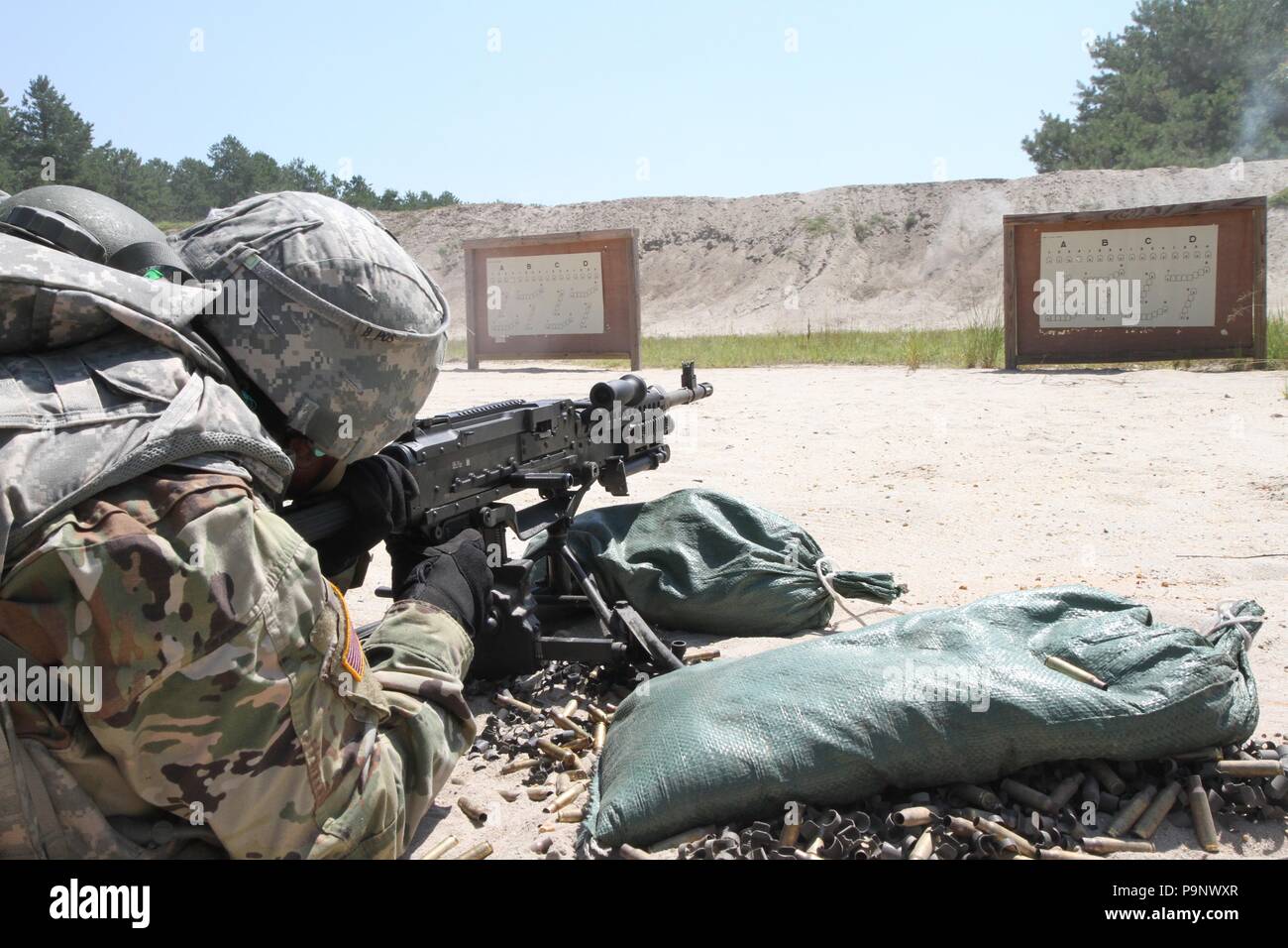 Brass ammunition shells fall and pile up next to a U.S. Army Reserve Soldier while qualifying on the M240B light machine gun during Operation Cold Steel II, hosted by the U.S. Army Civil Affairs and Psychological Operation Command at Joint Base McGuire-Dix-Lakehurst, N.J., July 11, 2018. Operation Cold Steel is the U.S. Army Reserve’s crew-served weapons qualification and validation exercise to ensure that America’s Army Reserve units and Soldiers are trained and ready to deploy on short notice and bring combat-ready and lethal firepower in support of the Army and our joint partners anywhere i Stock Photo