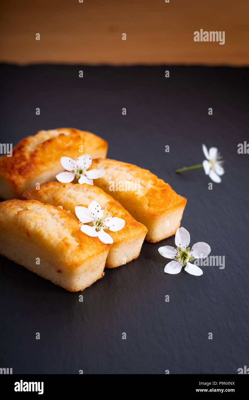 Food concept mini French almond cake financier on black slate stone with copy space Stock Photo