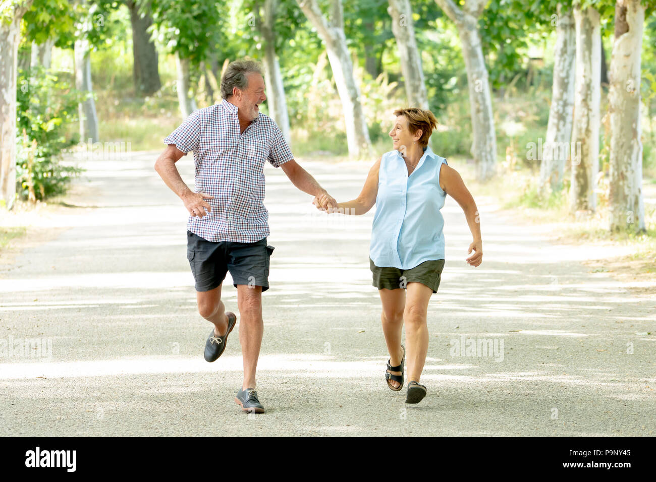 Happy beautiful senior couple in love walking and holding hands in the ...
