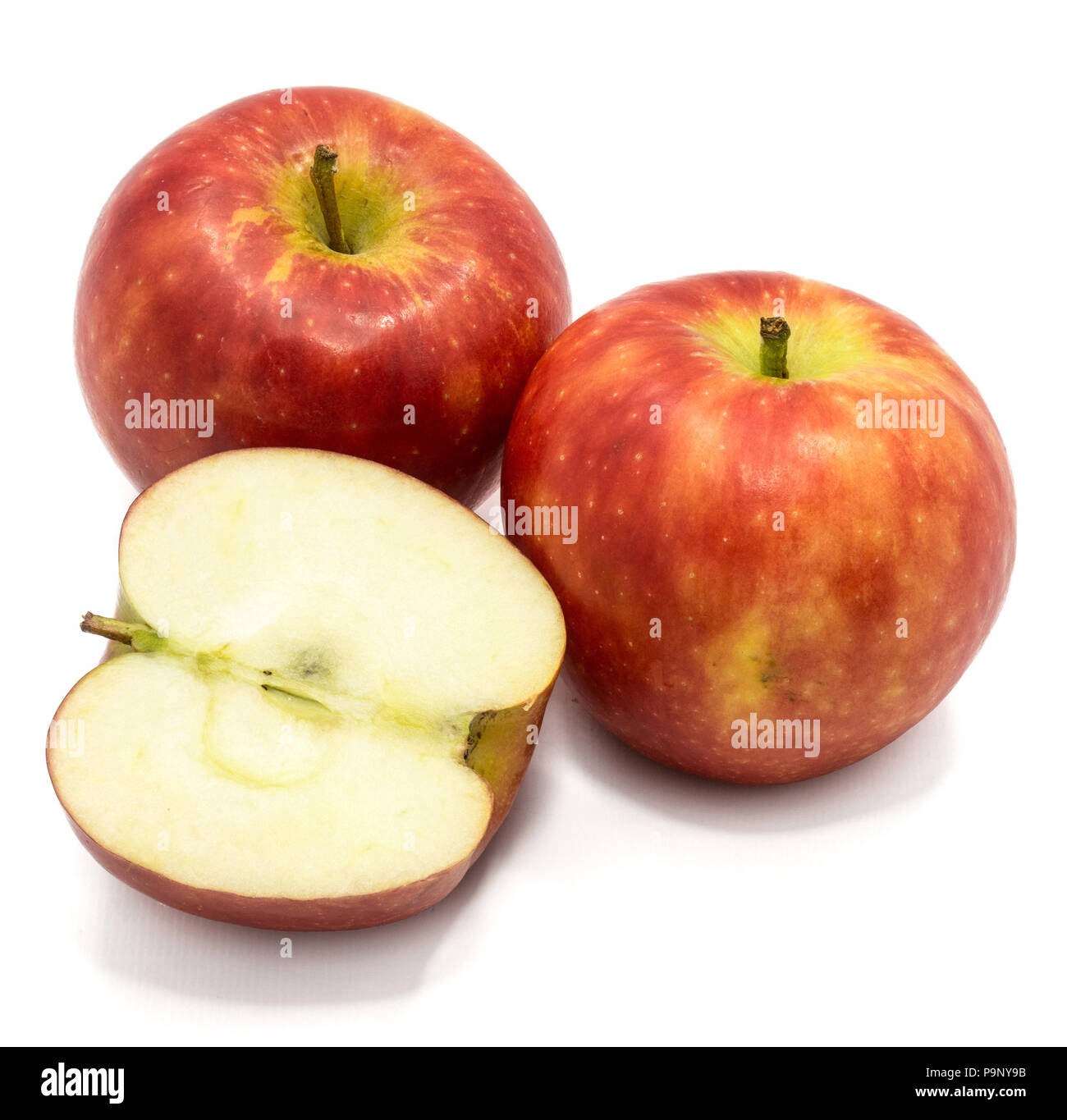 Red Kanzi apples, two whole, one half, isolated on white background