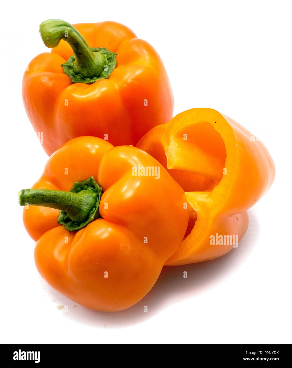 Group of two orange peppers, one whole and one cut pepper isolated on white background Stock