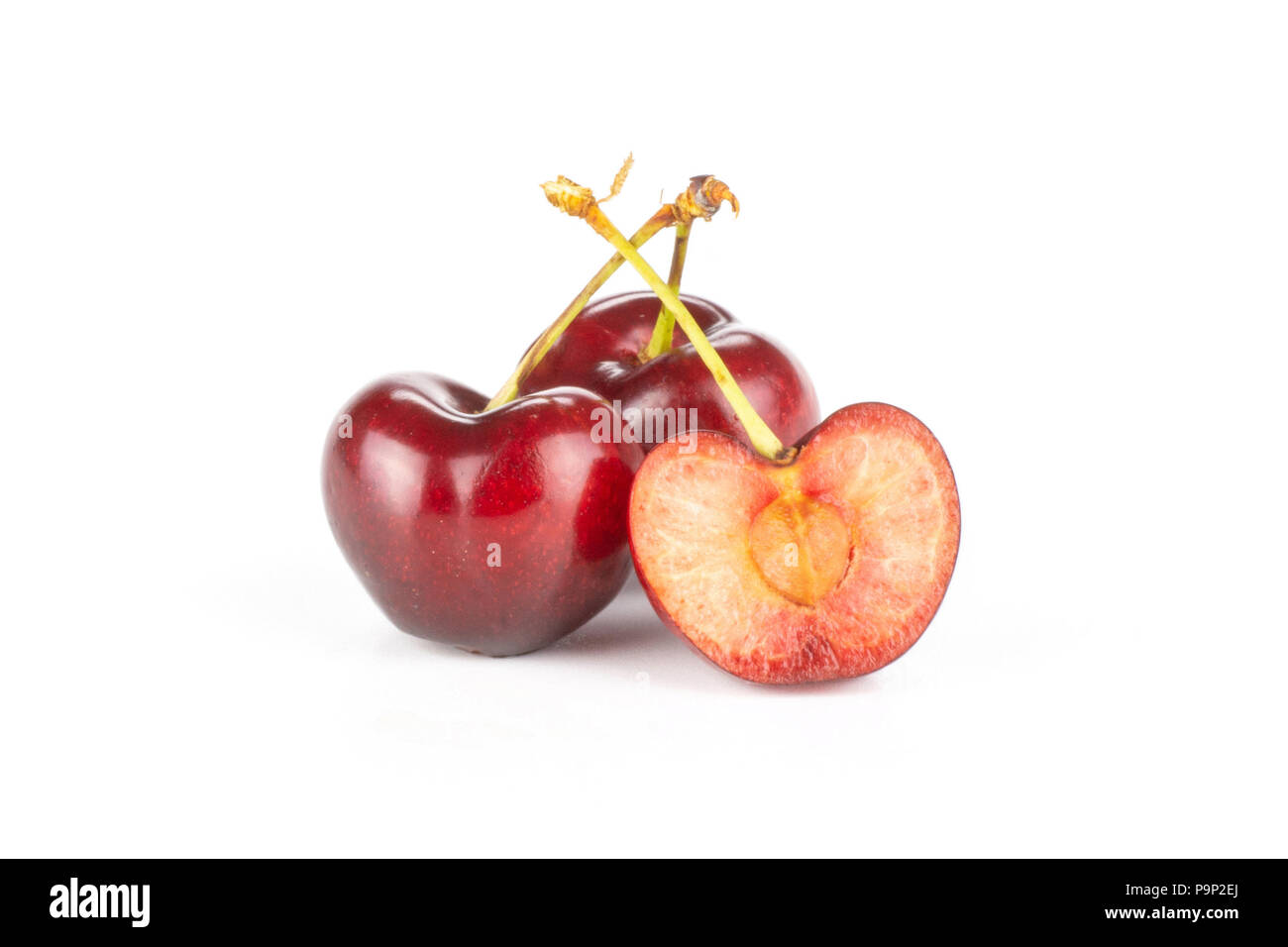 Group of two whole one half of sweet bright red cherry isolated on white Stock Photo