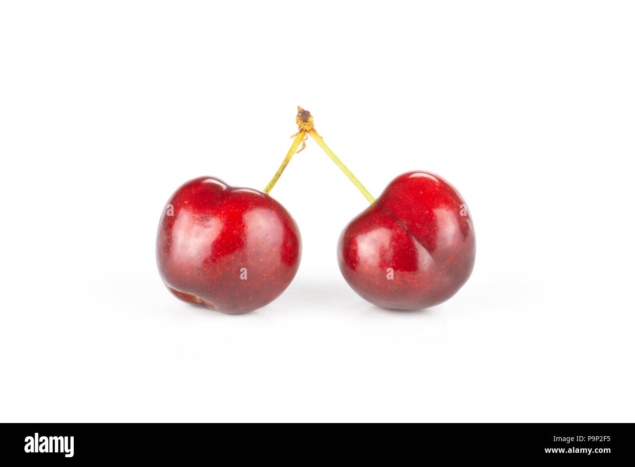 Group of two whole sweet bright red cherry joined stem isolated on white Stock Photo