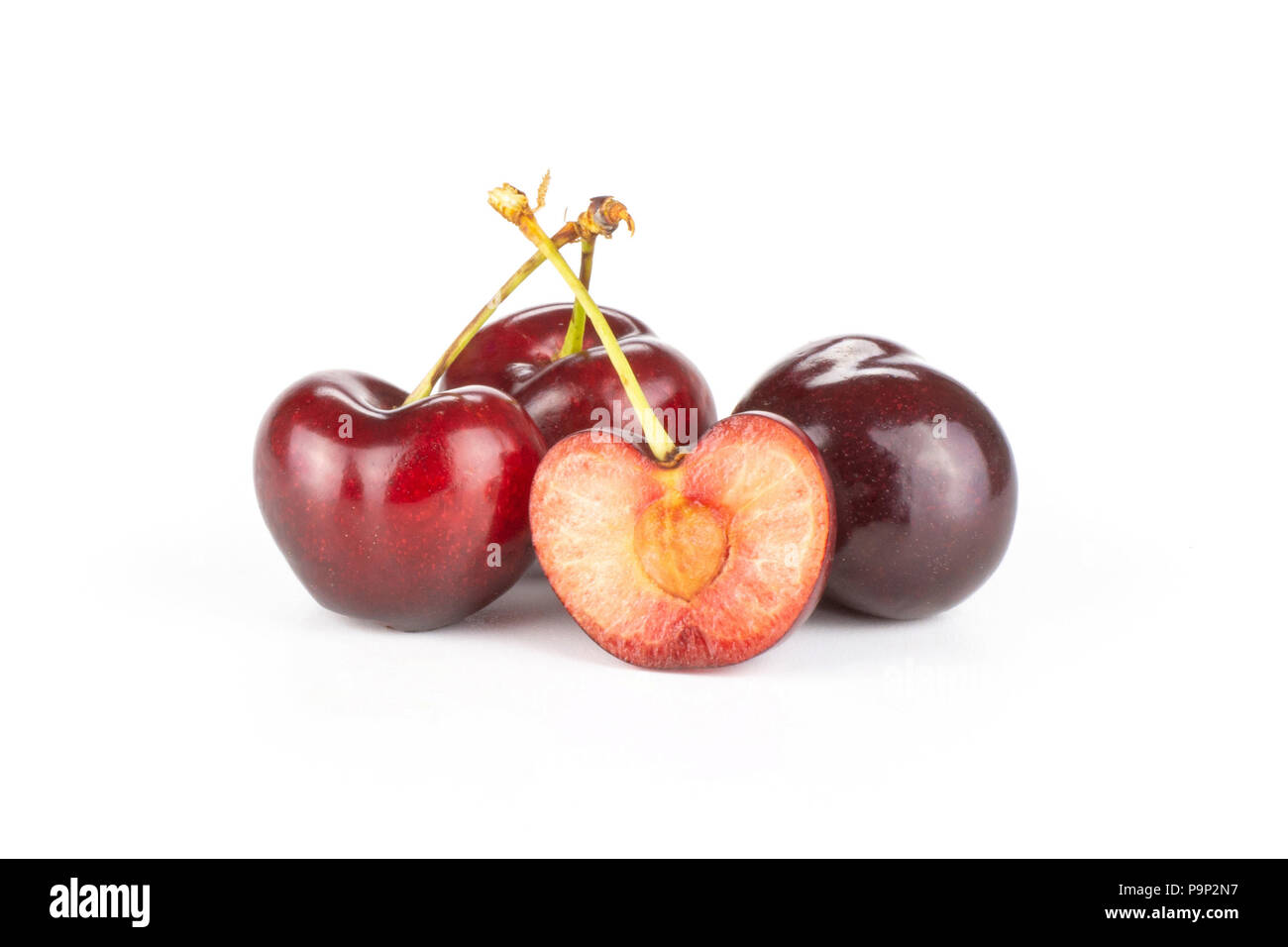 Group of three whole one half of sweet bright red cherry isolated on white Stock Photo