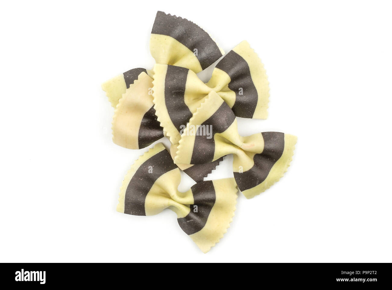 Farfalle pasta with black cuttlefish ink isolated on white background top view raw classic traditional Italian five pieces stack Stock Photo