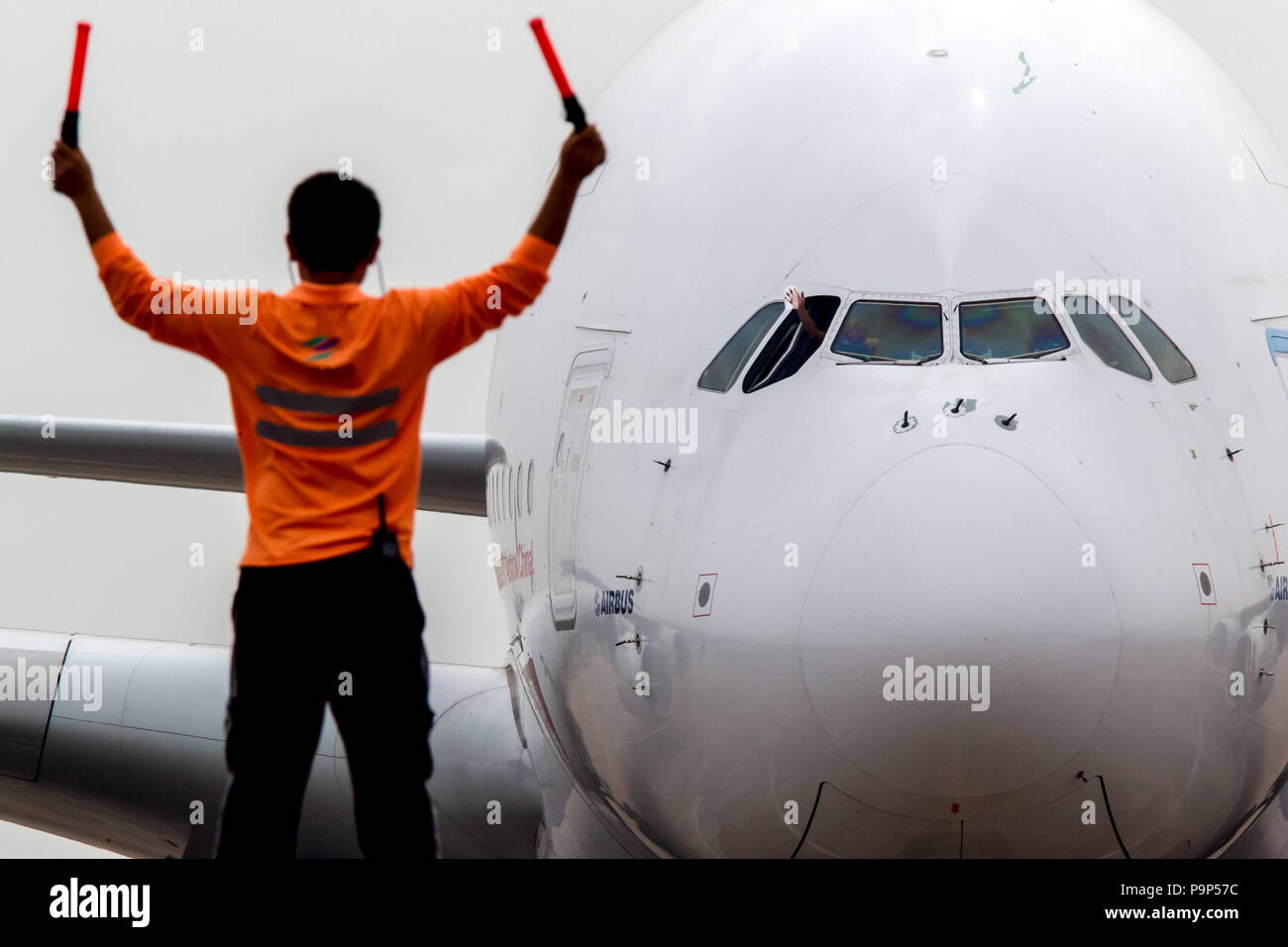 A marshaller pictured signaling the crew of the Airbus A380 at the Airshow China 2014 in Zhuhai, China. Stock Photo