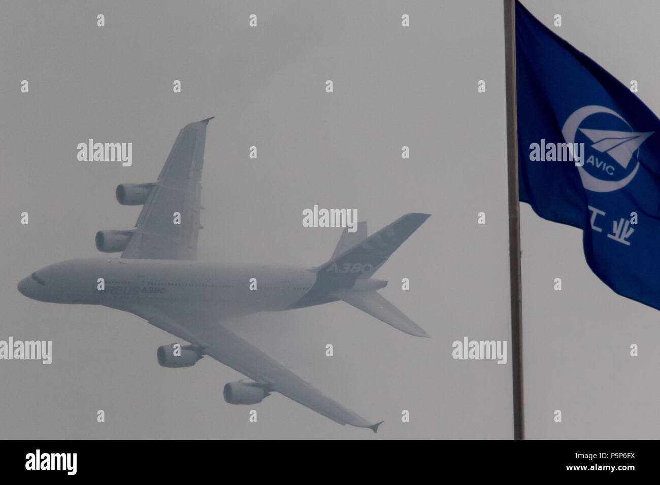 The Airbus A380 widebody jet airplane performs its demonstration flight behind the flag of AVIC (Aviation Industry Corporation of China) at the Airsho Stock Photo