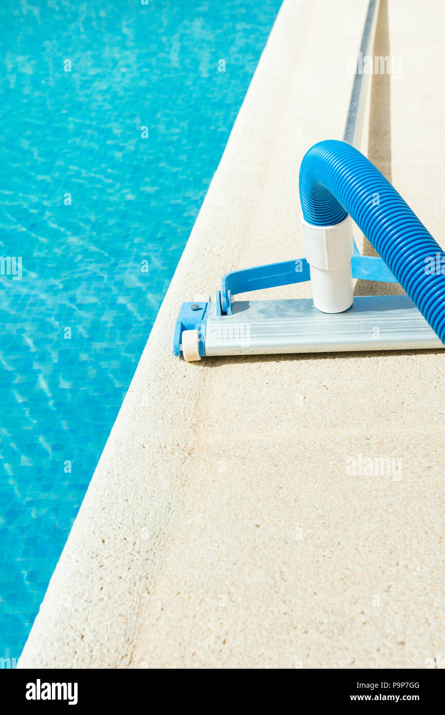 Manual Swimming Pool Vacuum Cleaner on Stone Deck. Bright Summer Sunny Day. Maintenance Cleaning Service Concept. Poster Banner with Copy Space Stock Photo