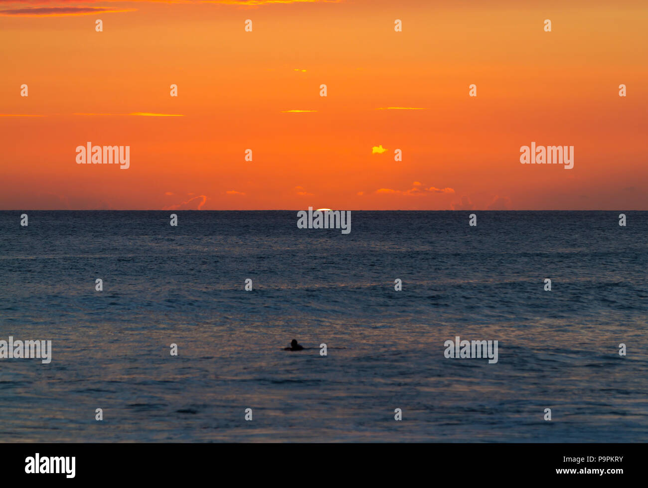 A Surfer Watching the 'Green Flash' at Sunset time Stock Photo