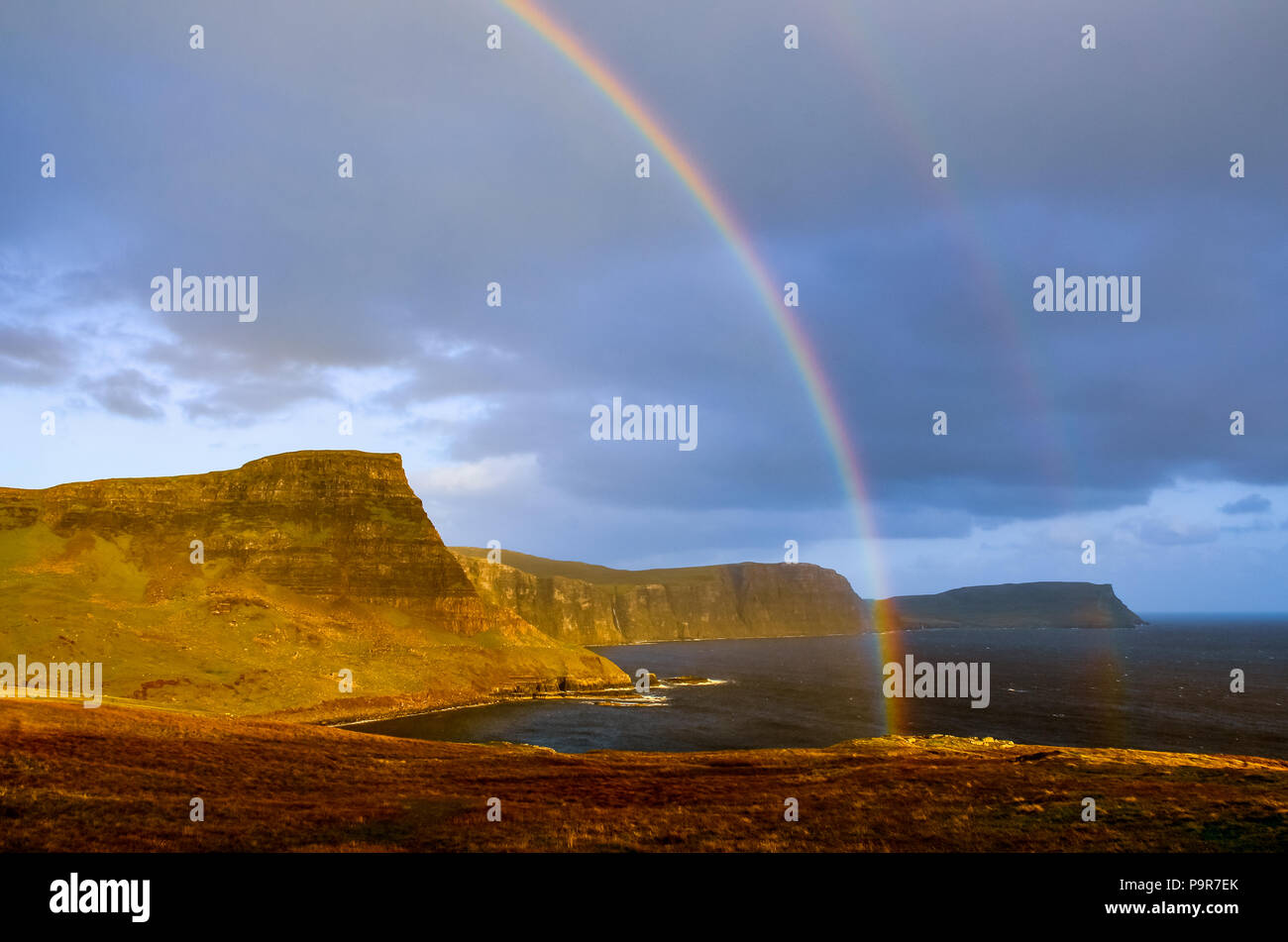 Rainbow over a dramatic coastline of Scottish highlands, Isle of Skye, United Kingdom, Europe Stock Photo