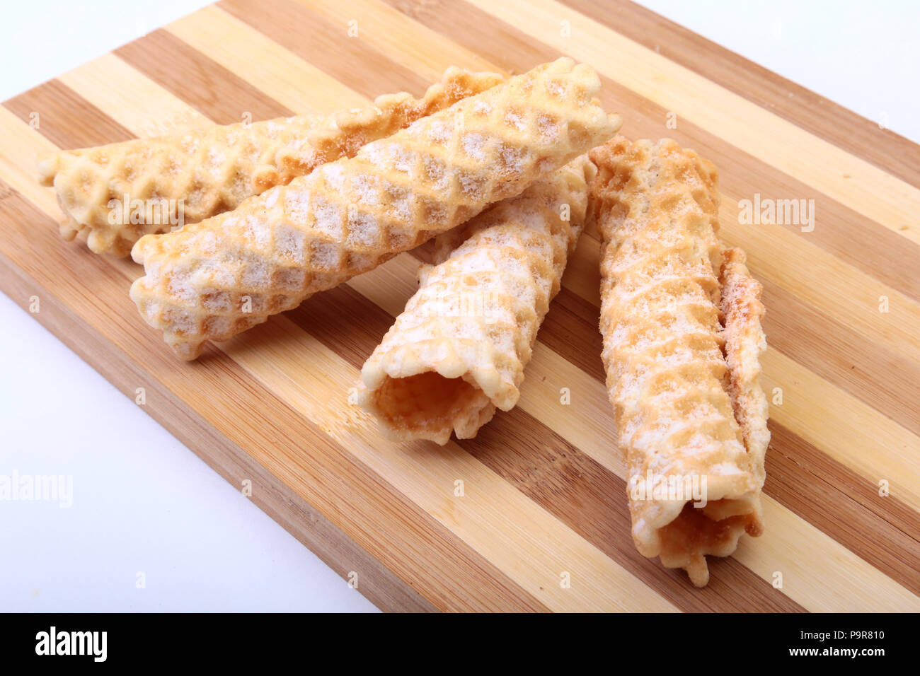 Homemade wafer rolls with powdered sugar isolated on white background Stock Photo