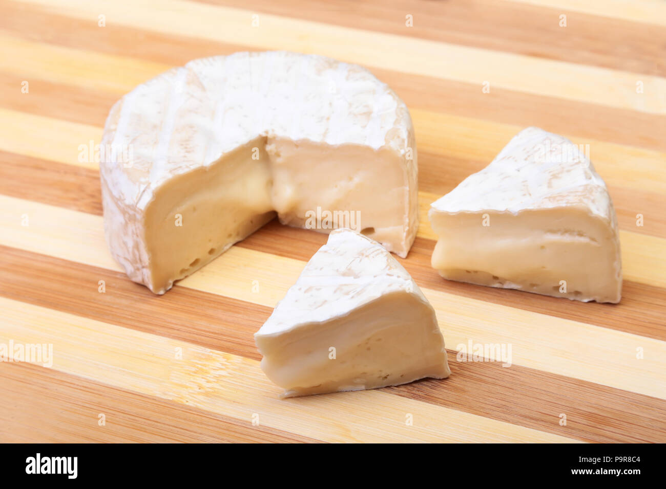 Cheese with white mold. Camembert or brie type on wood table. Healthy