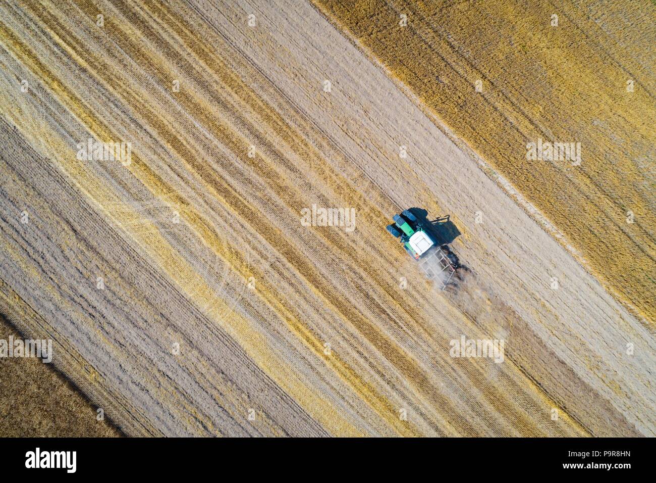 Aerial drone view of tractor plowing field after harvesting. Farm works ...