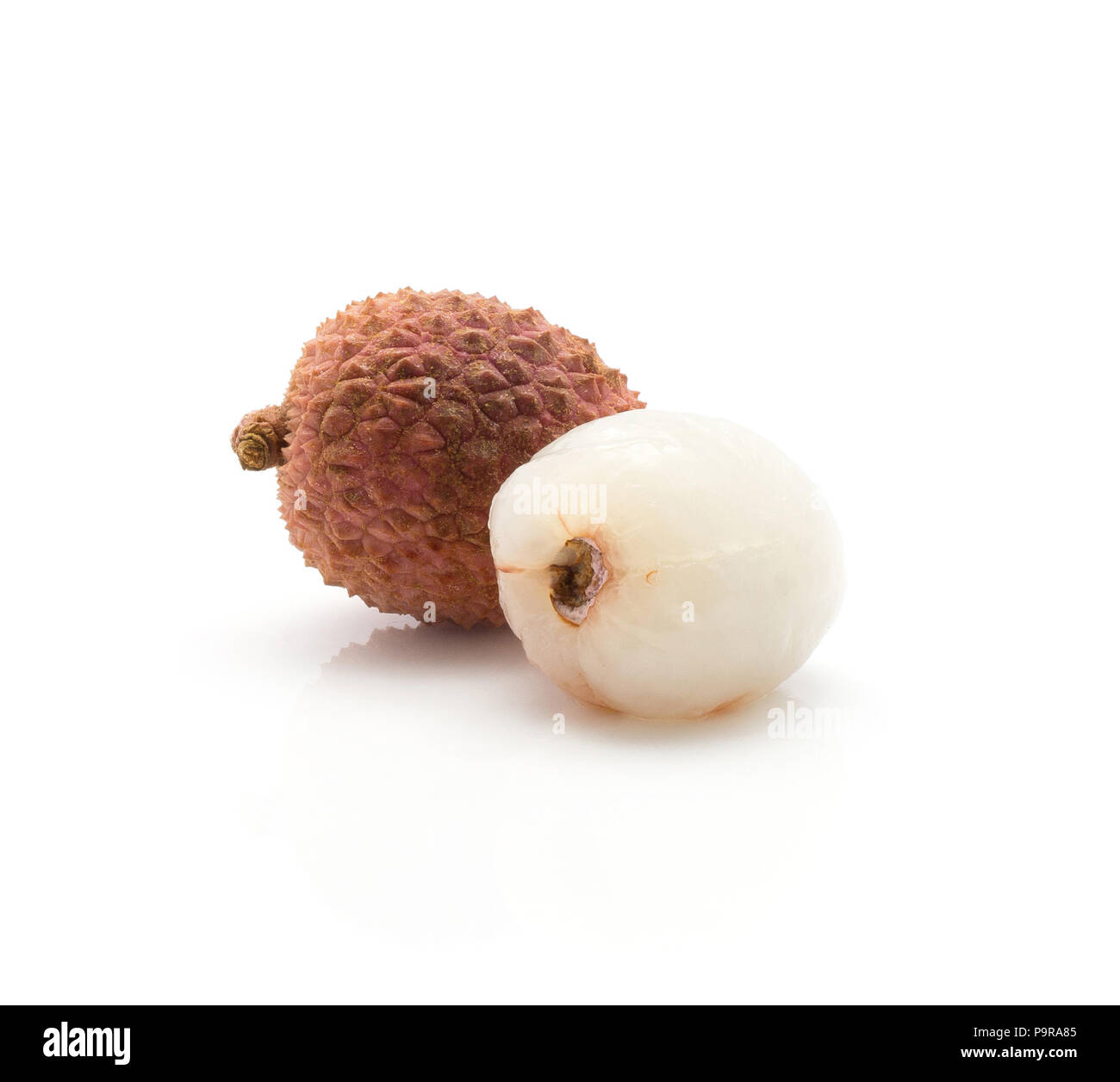 Two lychee one without shell isolated on white background ripe pink fresh berries Stock Photo