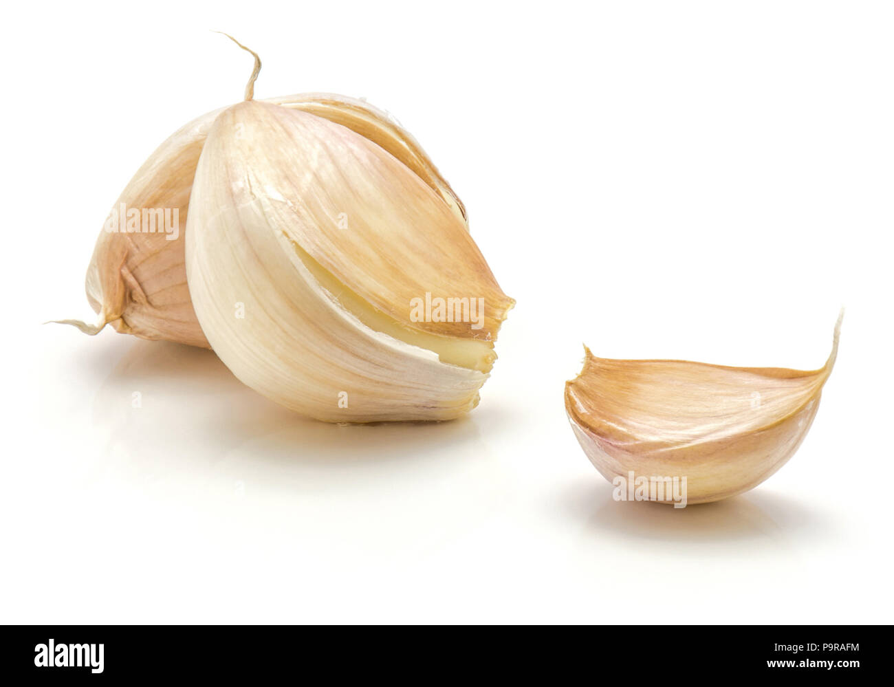 Three garlic cloves isolated on white background Stock Photo - Alamy