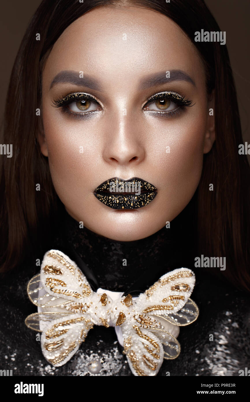 Beautiful girl with black creative art make-up and gold accessories. Beauty  face. Photos shot in studio Stock Photo - Alamy