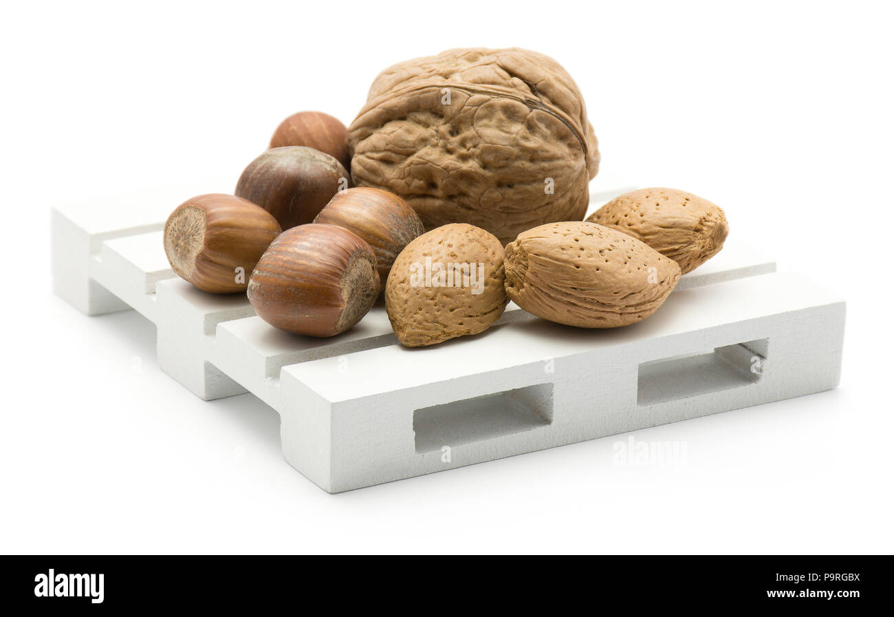 Nuts mix (walnut, hazelnut and almond) on a pallet isolated on white background Stock Photo