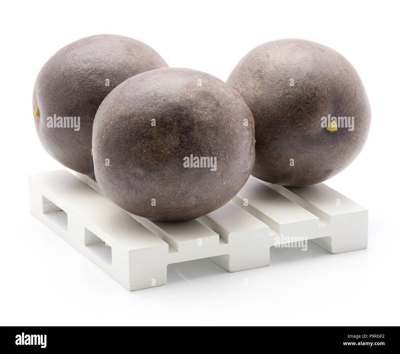 Three passion fruits on a pallet isolated on white background Stock Photo