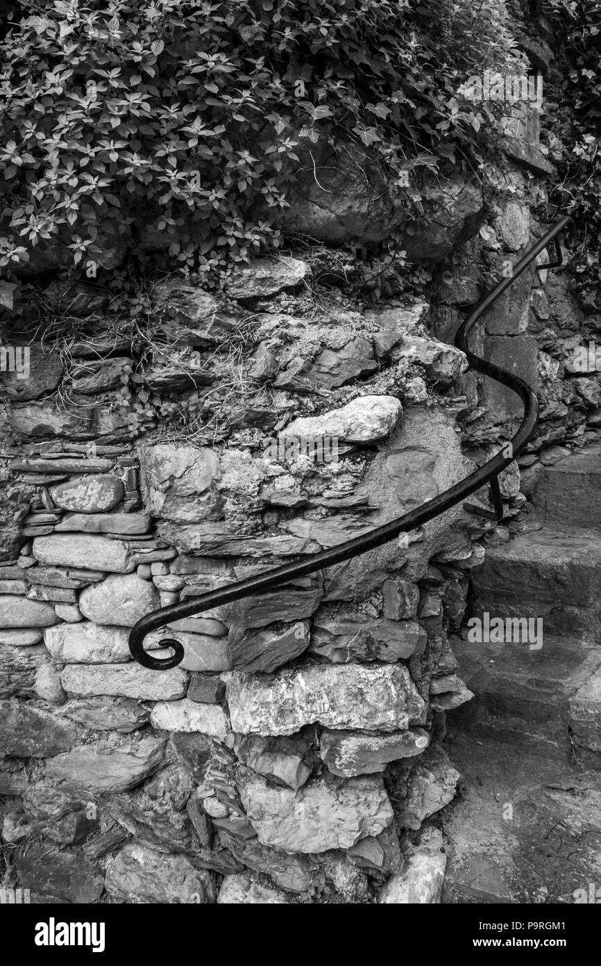 Wrought iron curved handrail on a granite stone wall by steps leading up to the church in Beget, Catalonia, Spain Stock Photo