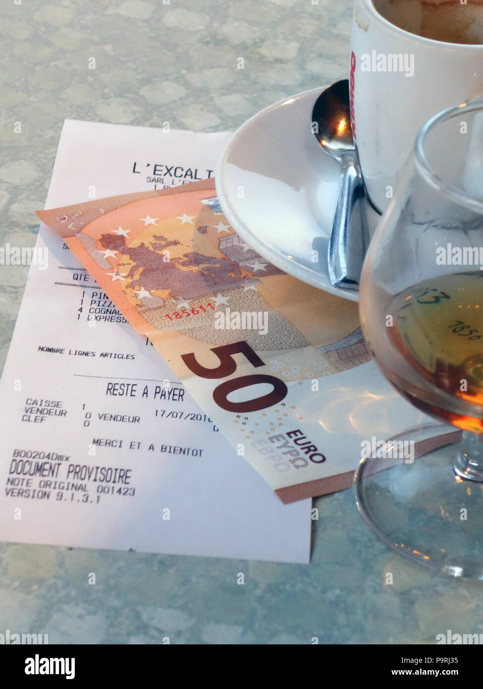 Large brandy and coffee with the bill after dinner in a restaurant in Magalas, Herault, South of France Stock Photo