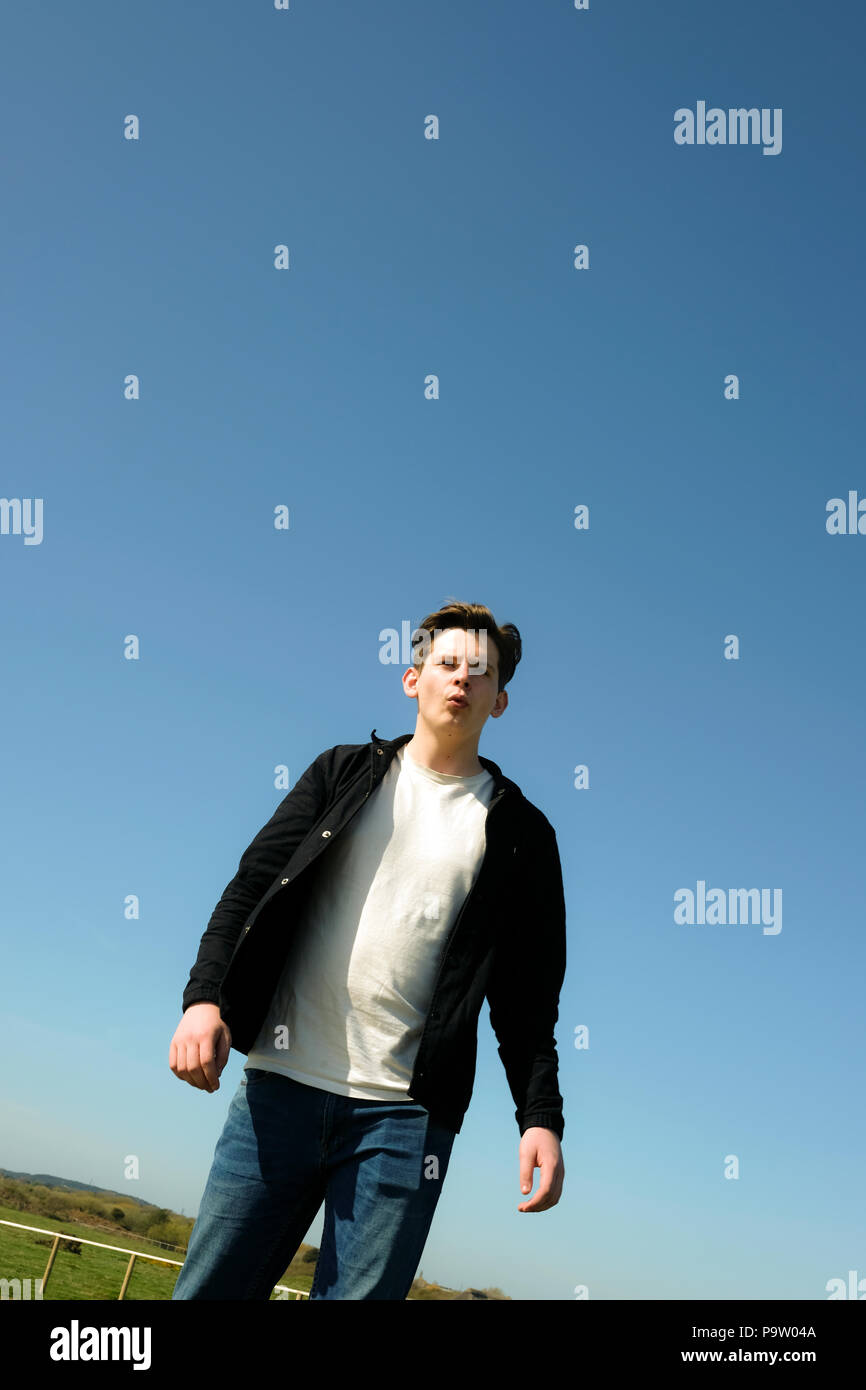 Low Angle Shot Of Casual Handsome Male Teenager Whistling And