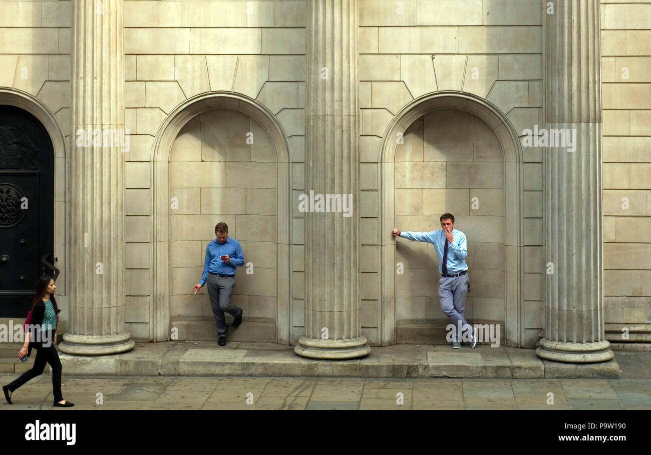 Two men stand  in alcoves next to the main entrance of the Bank of England, in the City of London, Britain July 5, 2018. Stock Photo