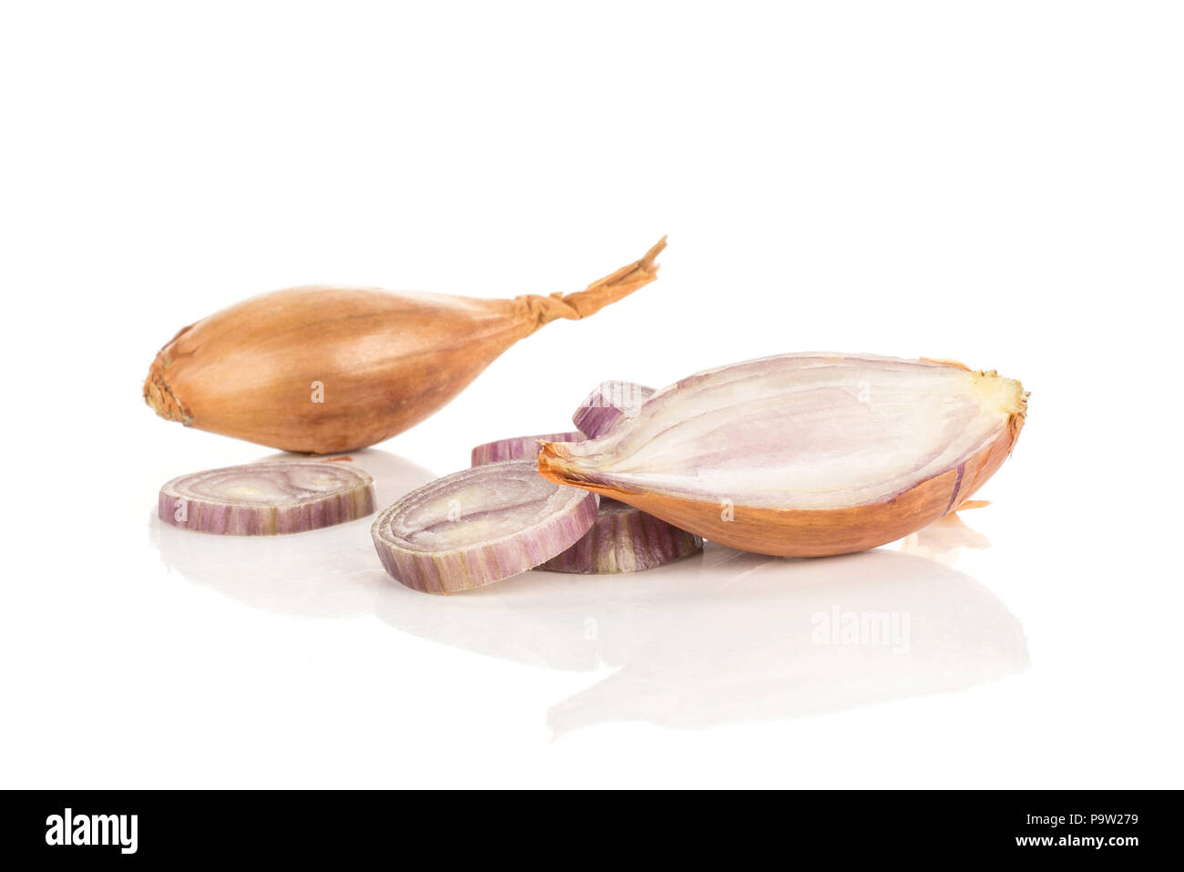 One golden shallot with section half and ring slices isolated on white