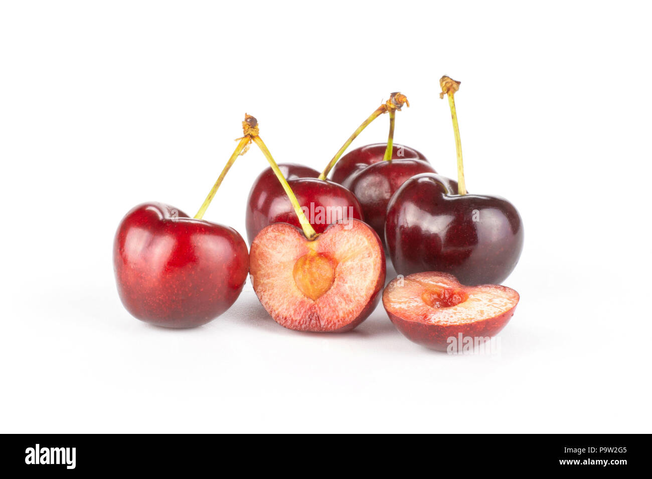 Group of four whole two halves of sweet bright red cherry isolated on white Stock Photo