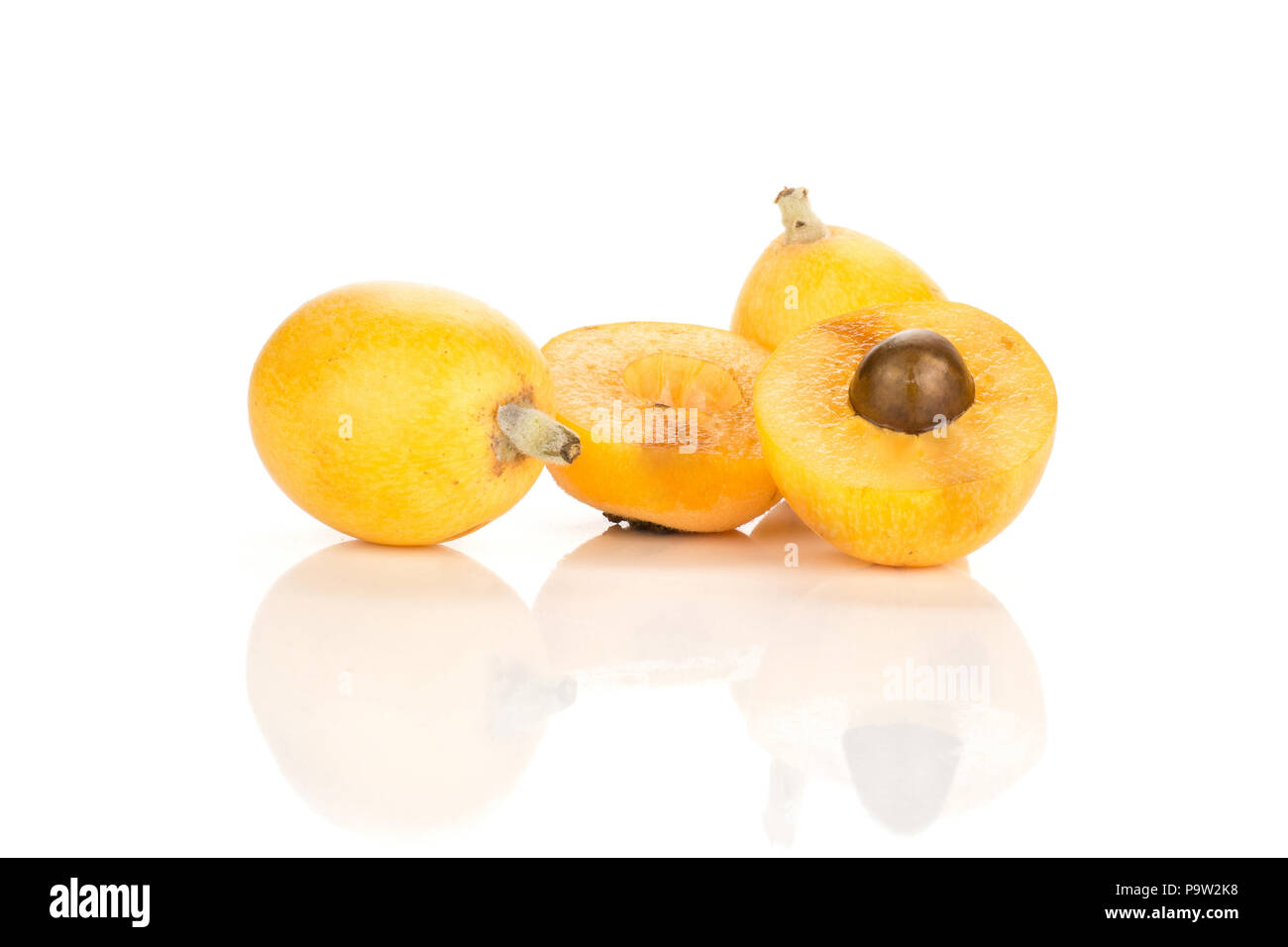 Two fresh orange Japanese loquat two halves isolated on white