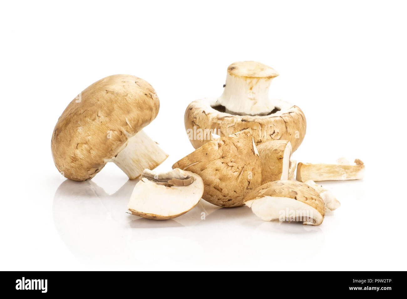 Two brown champignons and sliced pieces isolated on white background