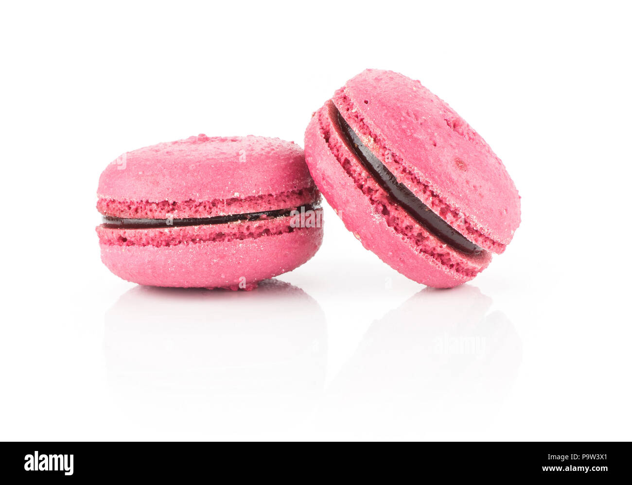 Pink French macarons two with raspberry jam isolated on white background Stock Photo