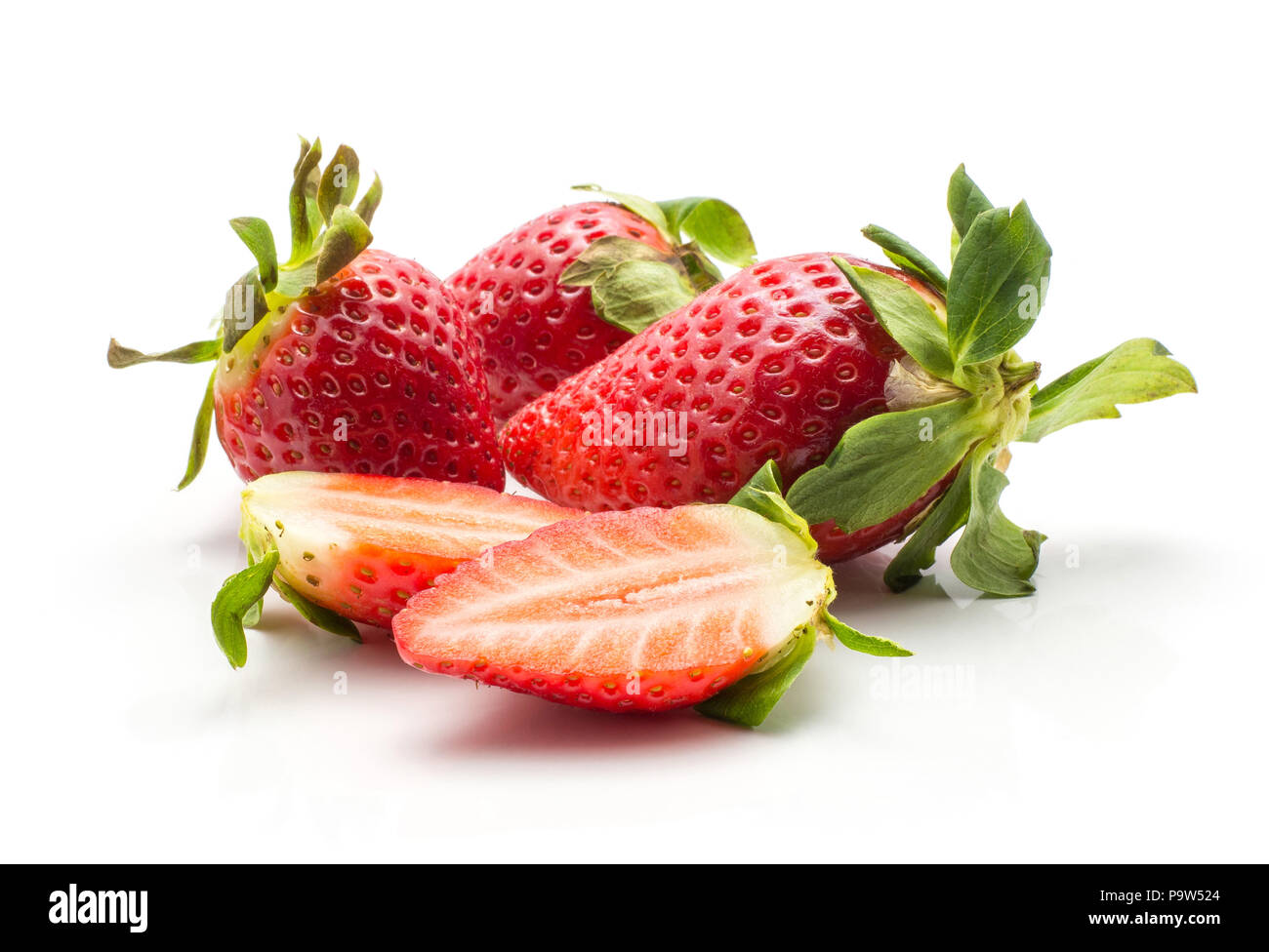 Three garden strawberrie and one sliced in two halves isolated on white background Stock Photo