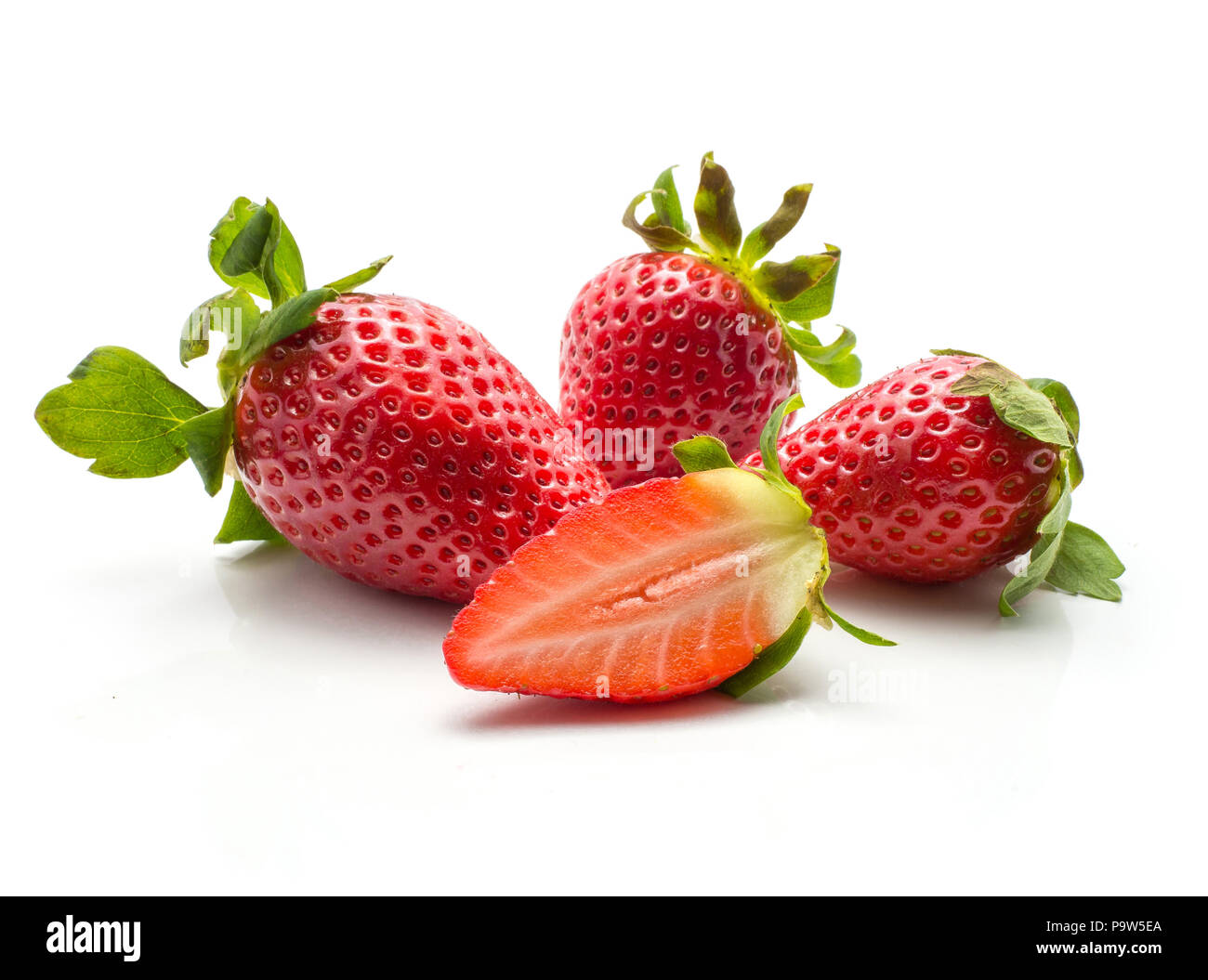 Three garden strawberries and one fresh cut half isolated on white background Stock Photo