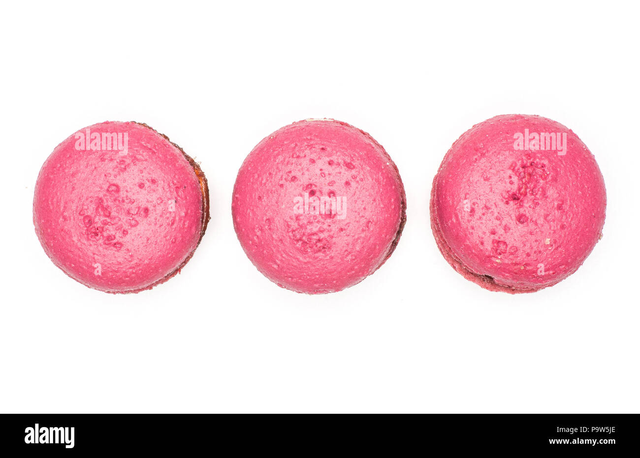 Pink French macarons top view isolated on white background three with raspberry jam in row Stock Photo