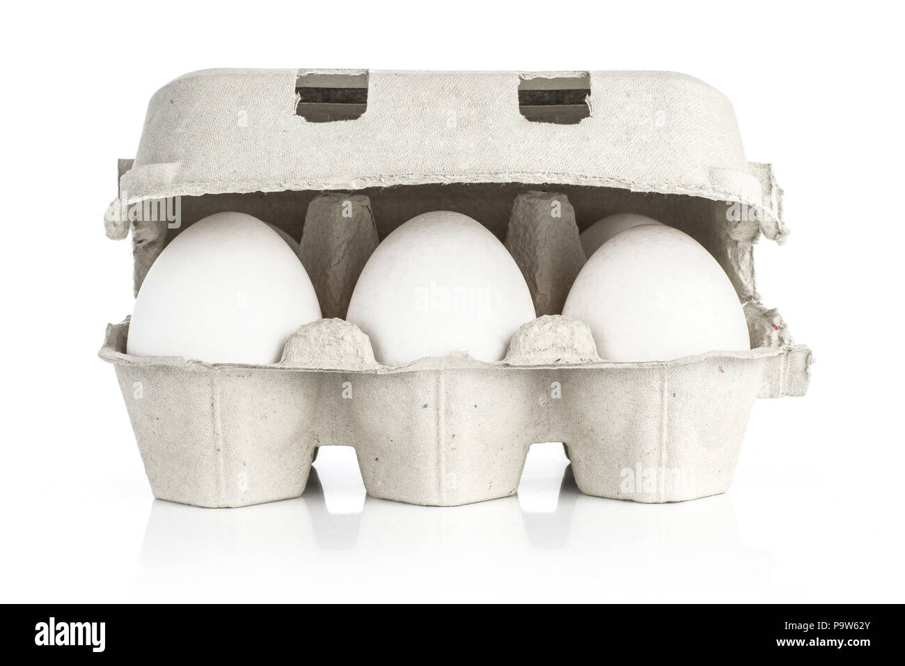 Six white chicken eggs in a paper grey crate isolated on white ...