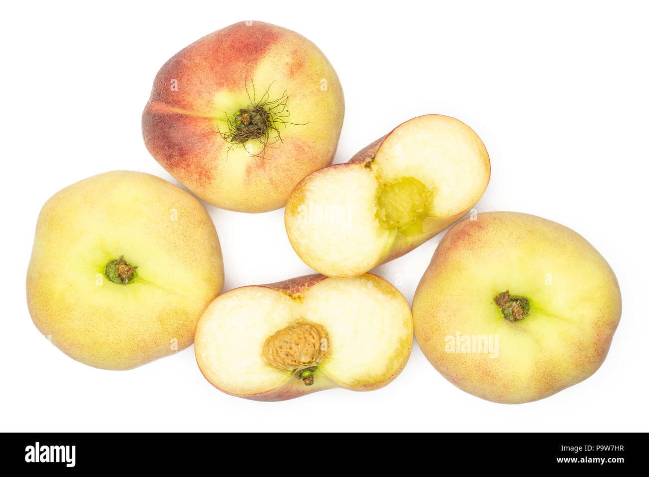 Three fresh ripe Saturn peaches and one cut in two halves top view