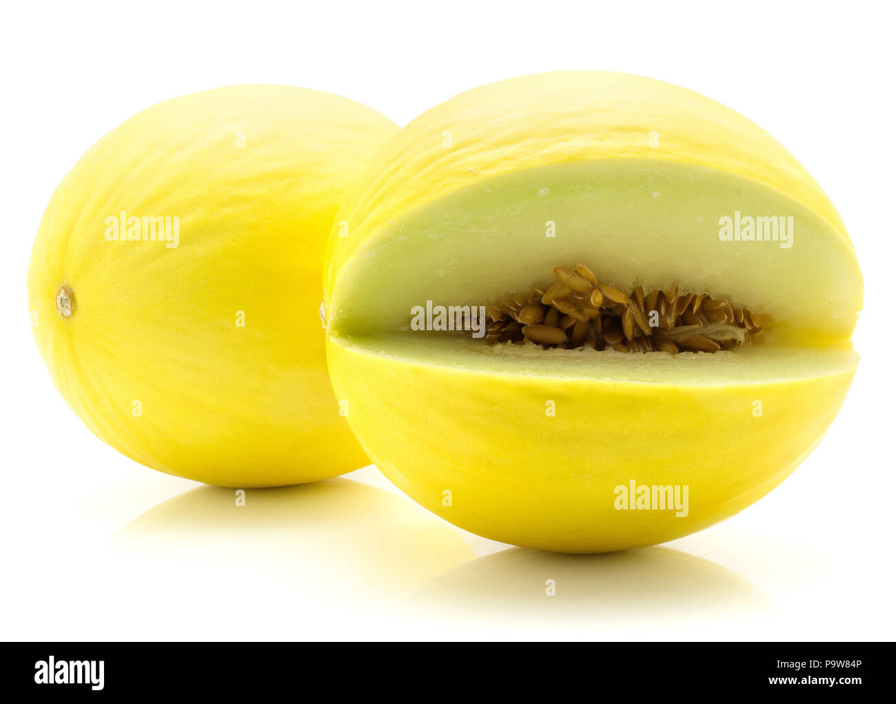 Two yellow honeydew melons isolated on white background one cut open with seeds inside Stock Photo