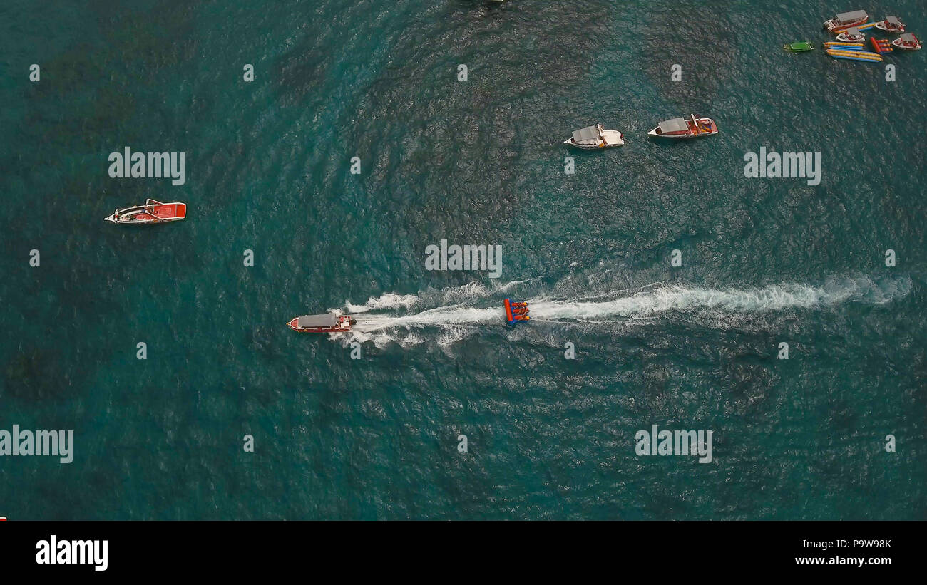 People having fun on banana boat. Group of people riding banana boat
