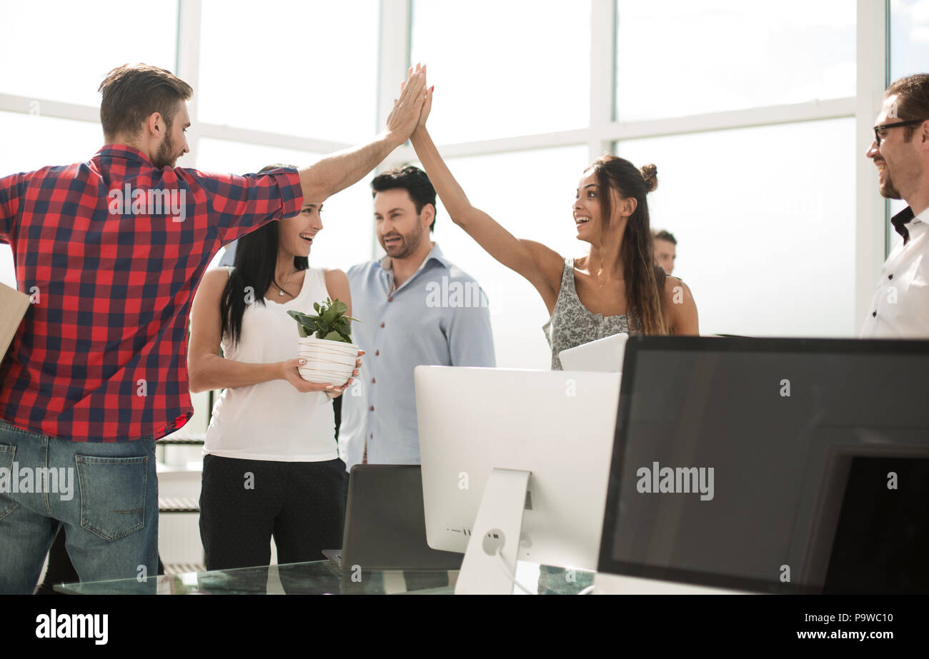 business team is giving each other a high five in the new office Stock ...