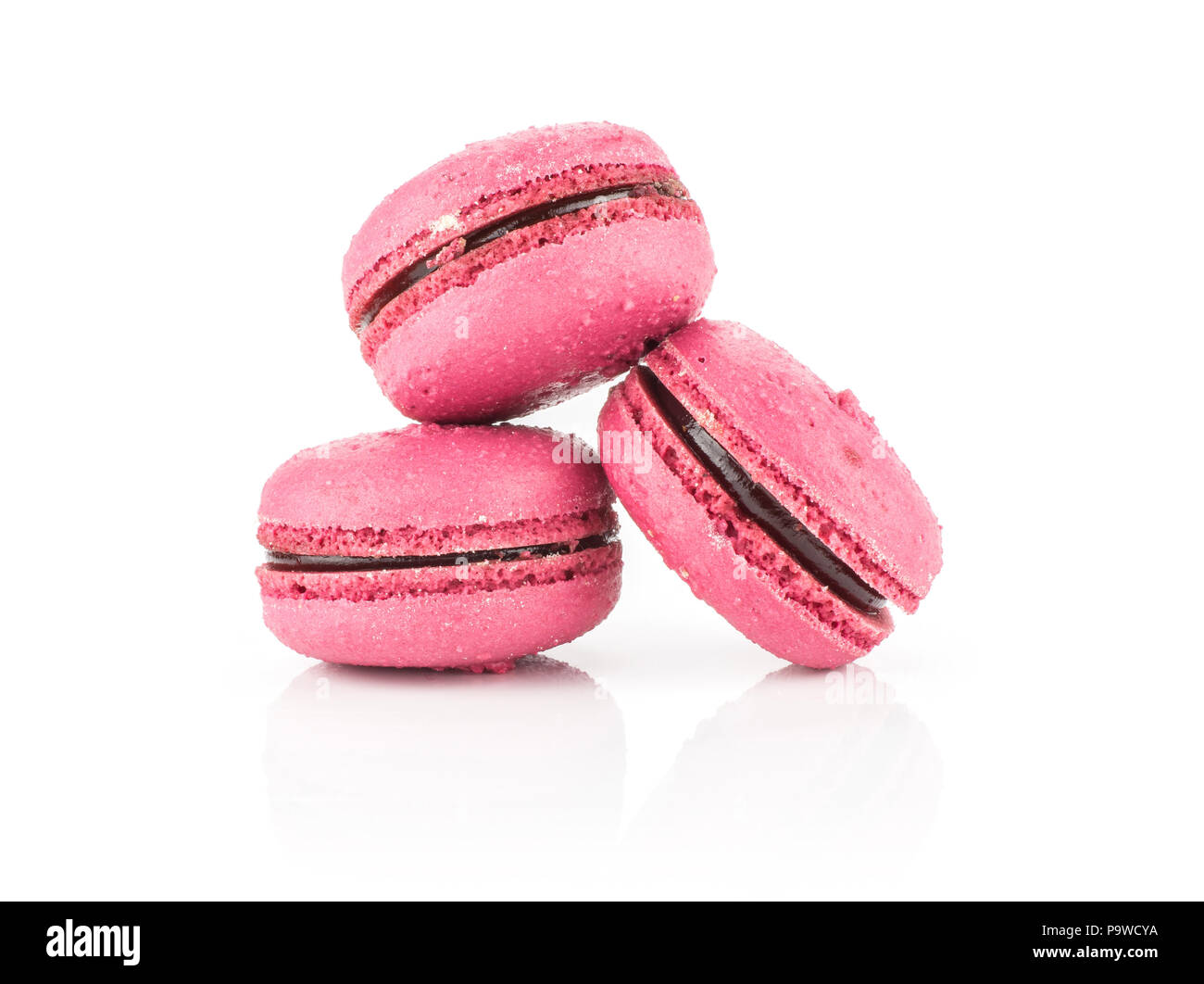 Pink French macarons isolated on white background three with raspberry jam Stock Photo