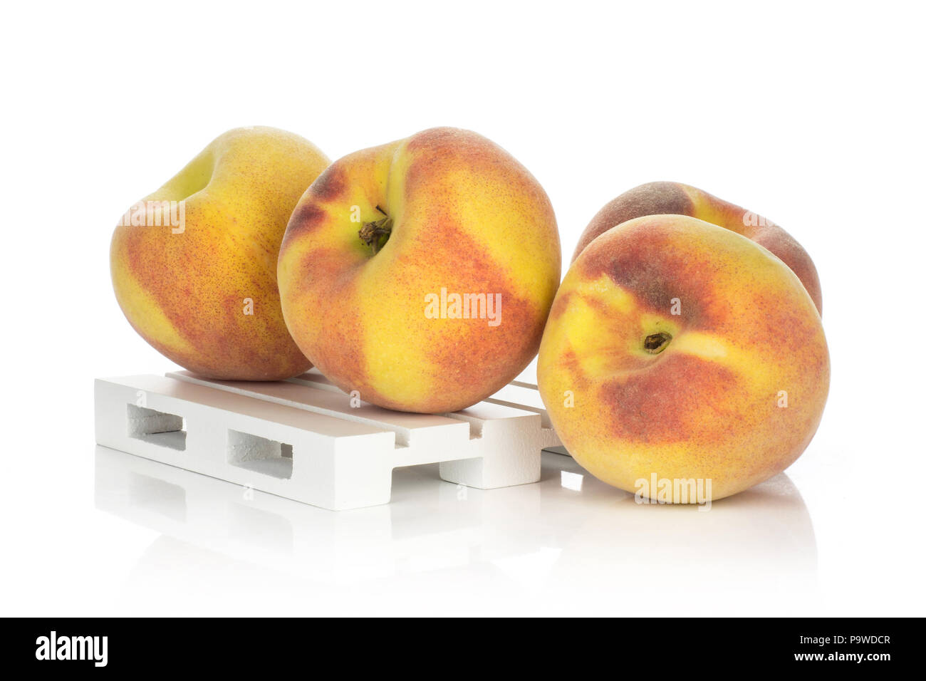 Yellow peaches on a wooden pallet isolated on white background Stock Photo
