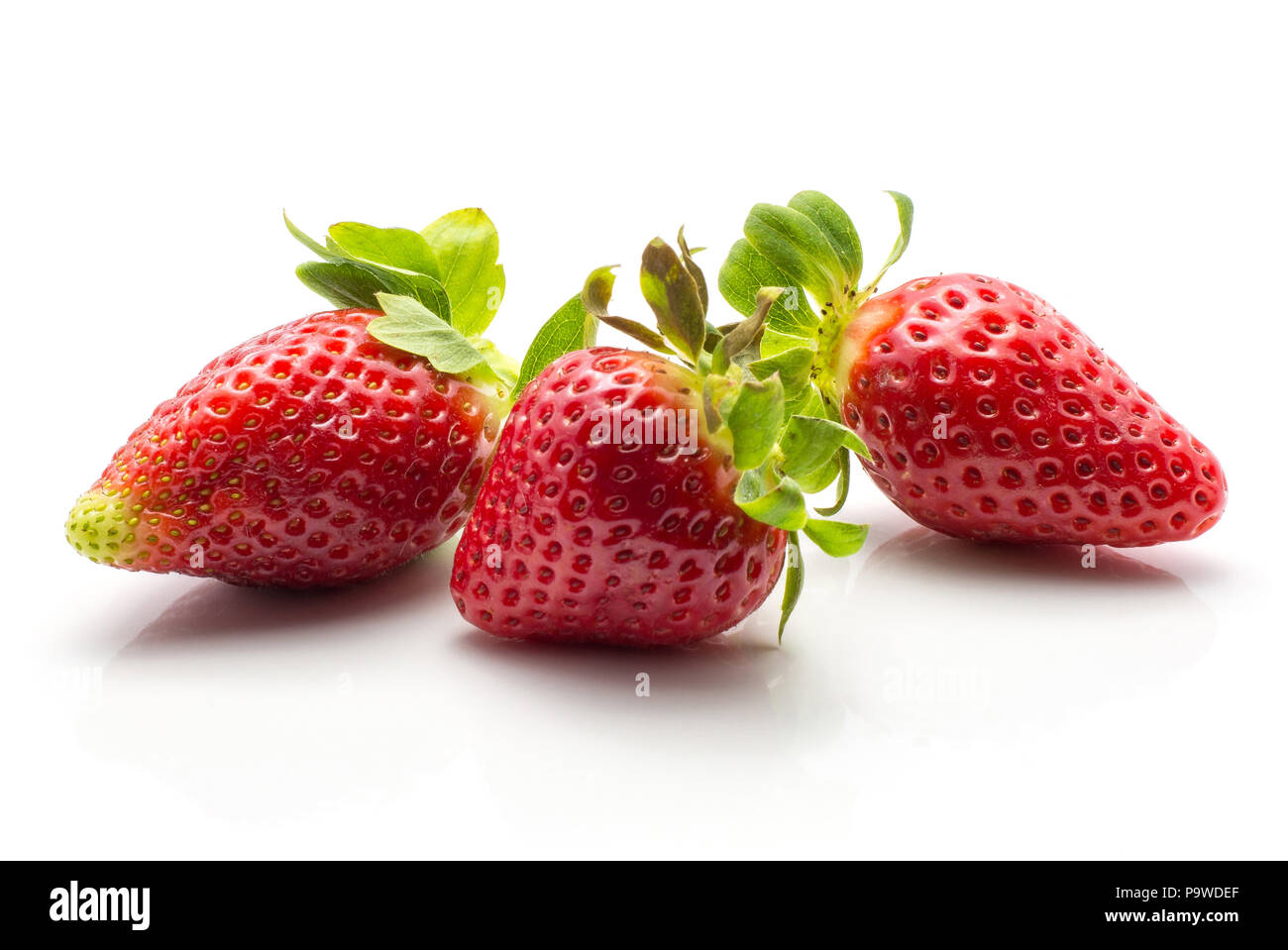 Three garden strawberries isolated on white background ripe fresh Stock Photo