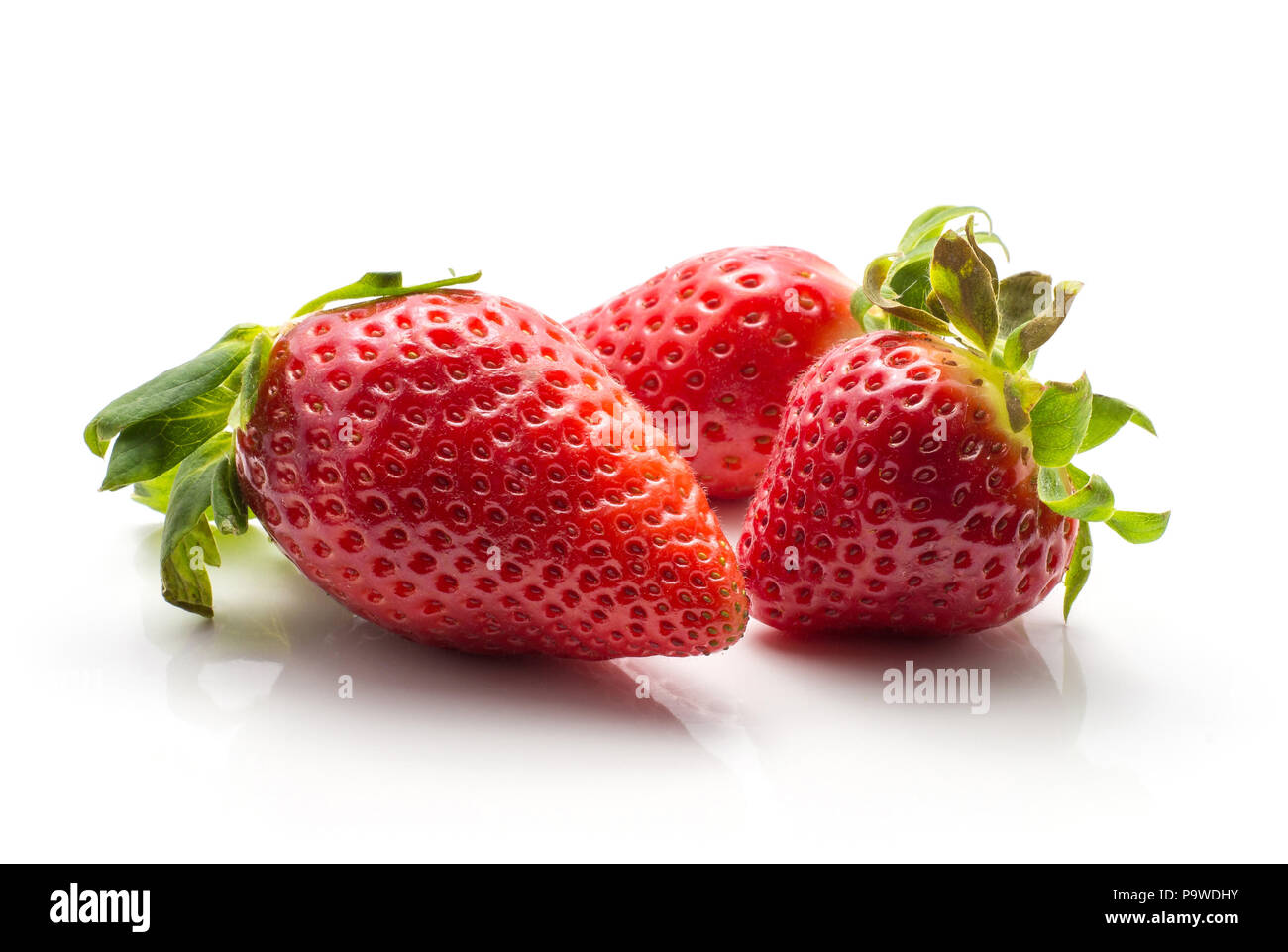 Three garden strawberries isolated on white background ripe and fresh Stock Photo