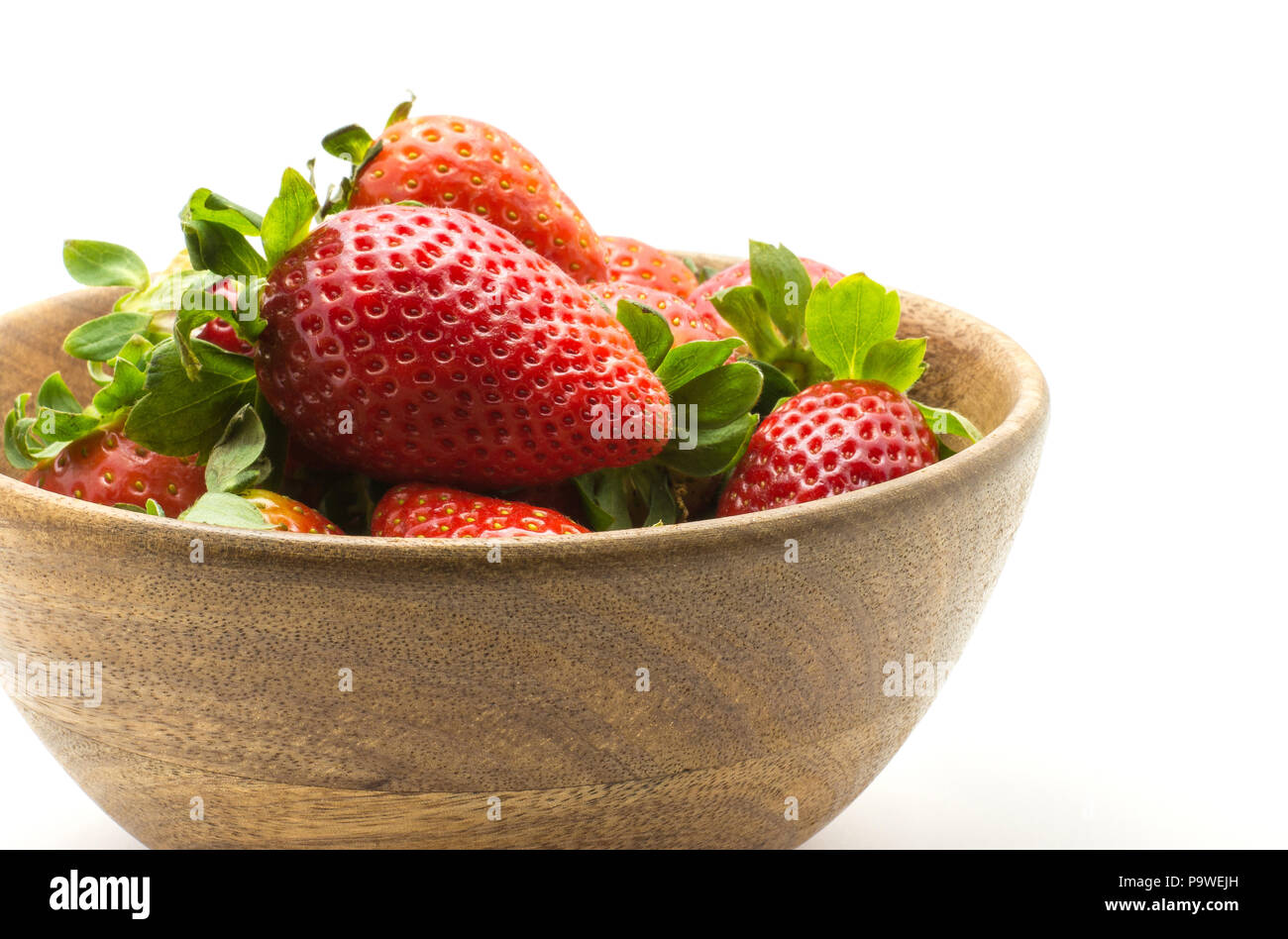 Strawberries in a wooden bowl isolated on white background Stock Photo