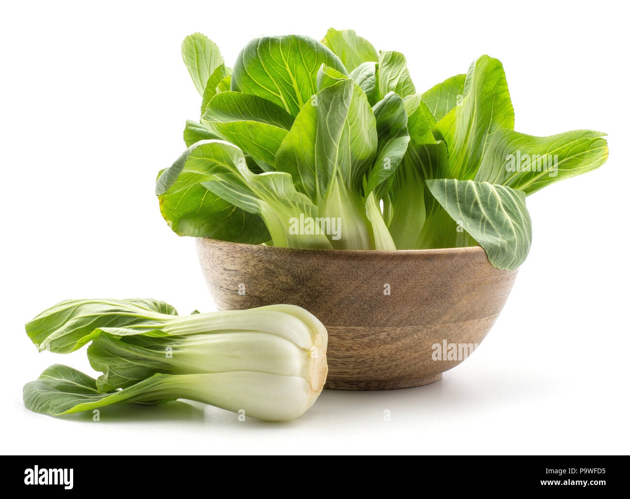 Fresh bok choy (Pak choi) in a wooden bowl one cabbage is near isolated on white background Stock Photo