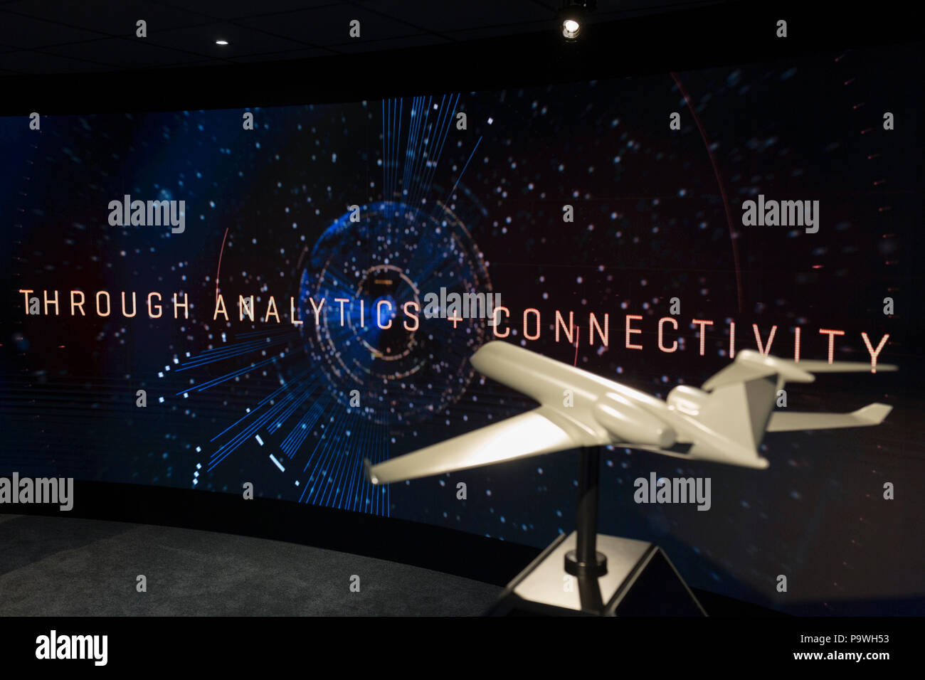 A model of a generic aircraft and the images from a video presentation in the exhibition chalet of United Technologies, at the Farnborough Airshow, on 16th July 2018, in Farnborough, England. United Technologies are the parent company to  Otis,, UTC Climate, Controls & Security, Pratt ＆ Whitney and UTC. Stock Photo