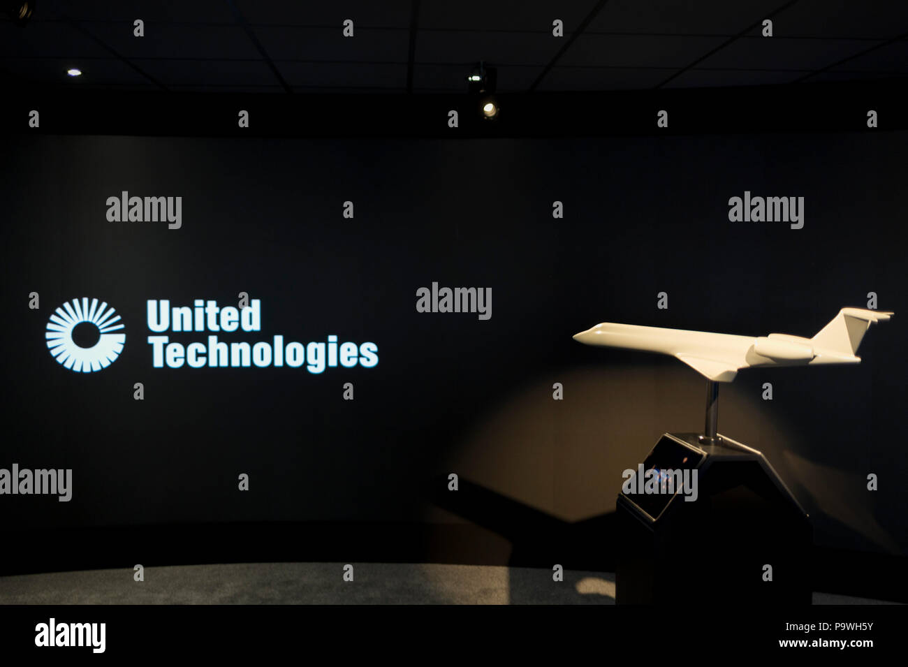 A model of a generic aircraft and the images from a video presentation in the exhibition chalet of United Technologies, at the Farnborough Airshow, on 16th July 2018, in Farnborough, England. United Technologies are the parent company to  Otis,, UTC Climate, Controls & Security, Pratt ＆ Whitney and UTC. Stock Photo