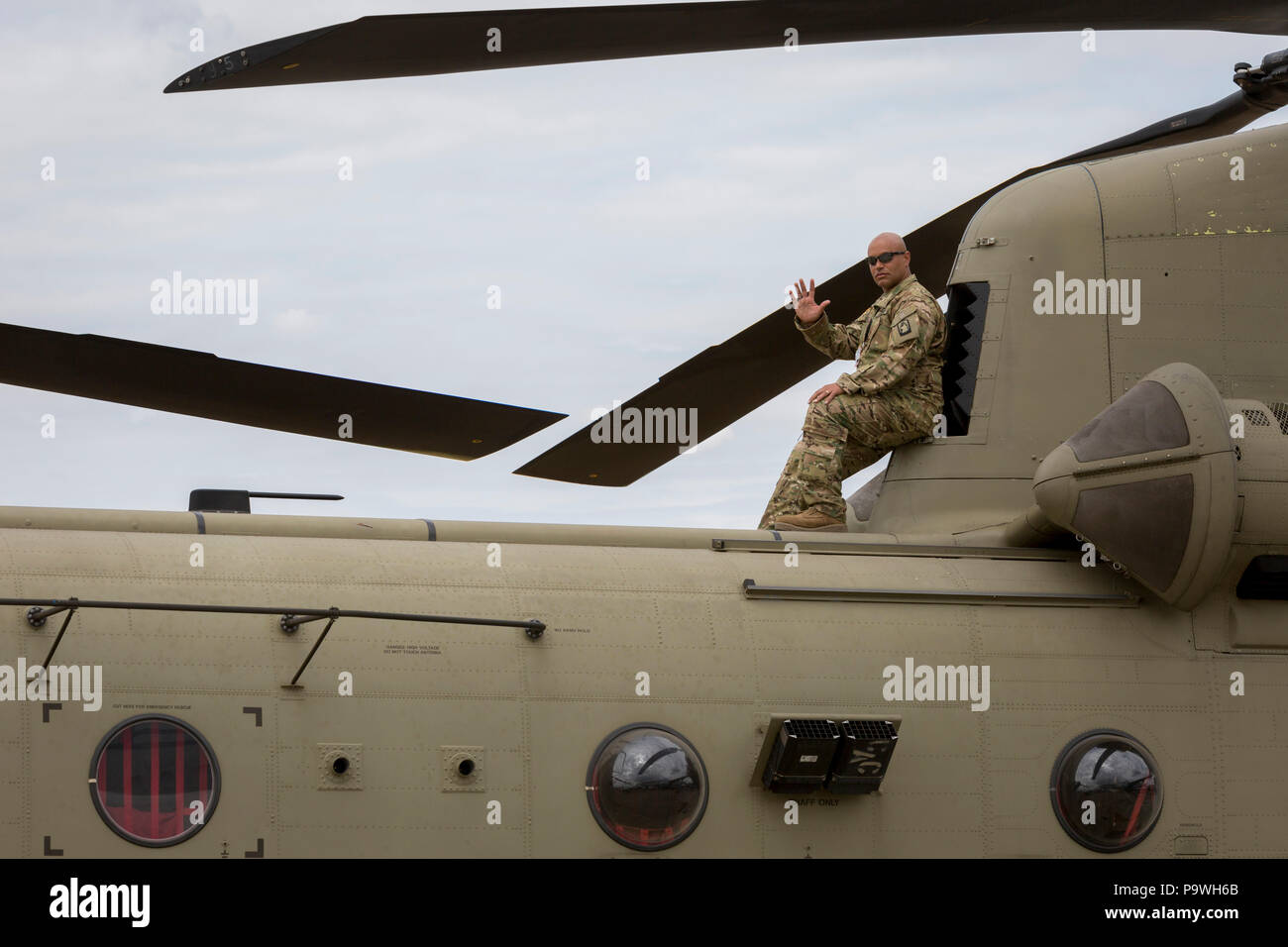 A serviceman with the United States Army watches the flying show from the top of his Chinook helicopter at the Farnborough Airshow, on 18th July 2018, in Farnborough, England. Stock Photo