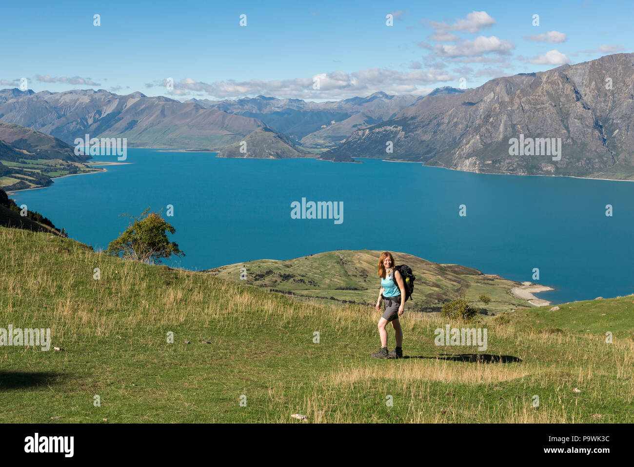 Female hiker at Isthmus Peak Track, Lake Hawea and mountain panorama, Otago, South Island, New Zealand Stock Photo